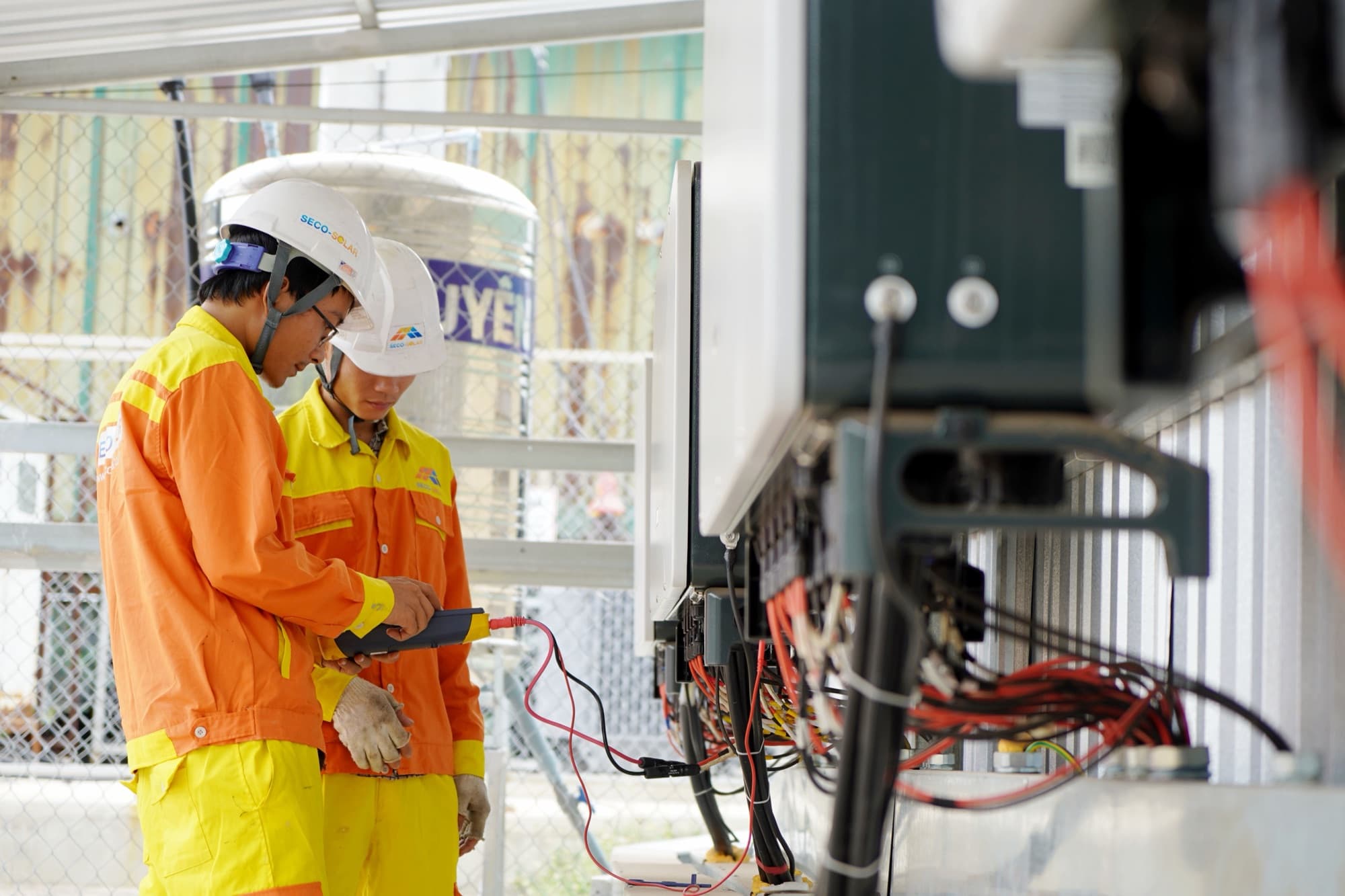 Engineers in hard hats inspecting an electrical substation